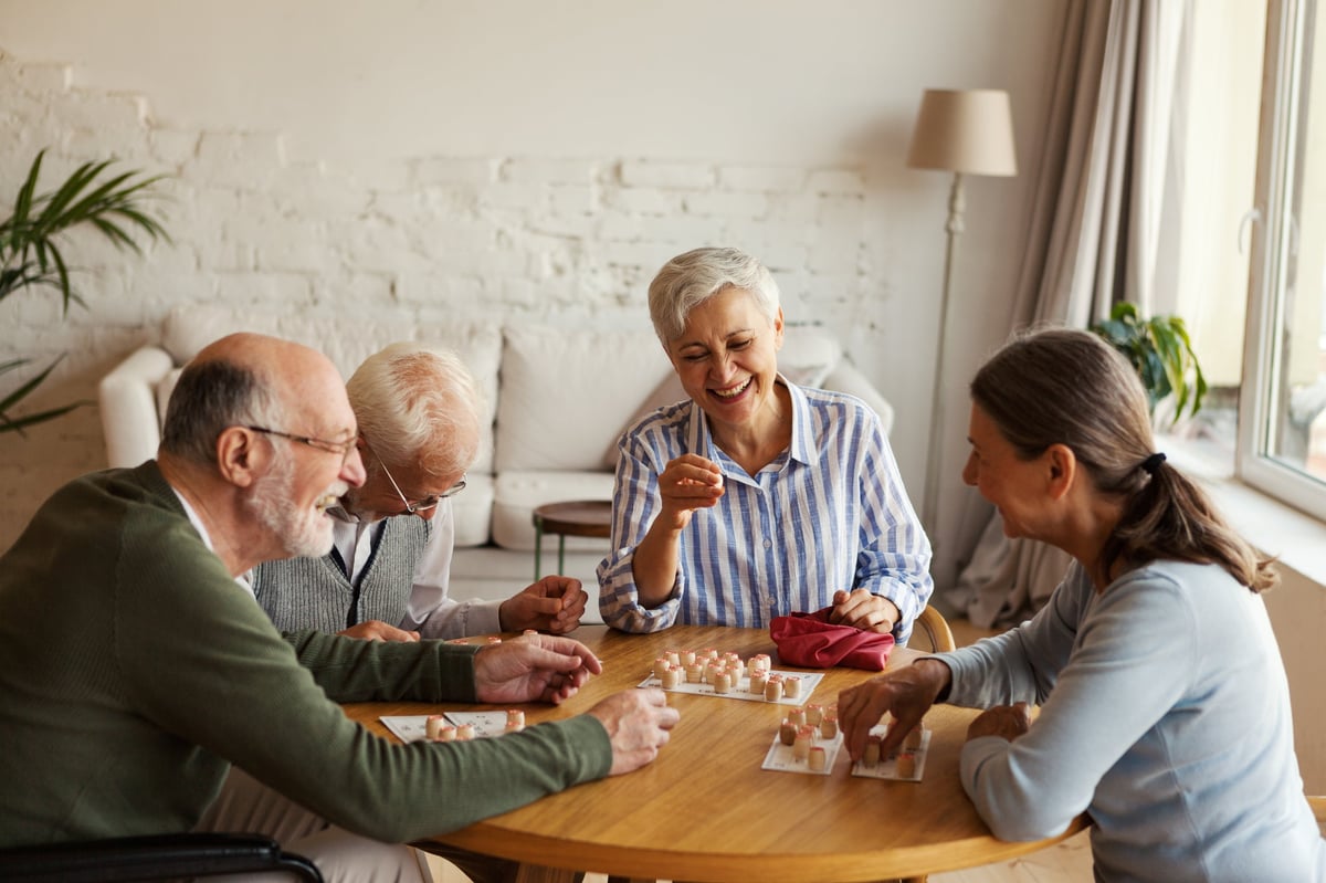 Members playing a lively game together in Denver Adult Daycare's bright, welcoming common room